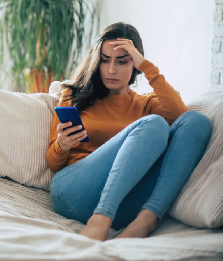 A woman on her couch on a hard day of her cycle