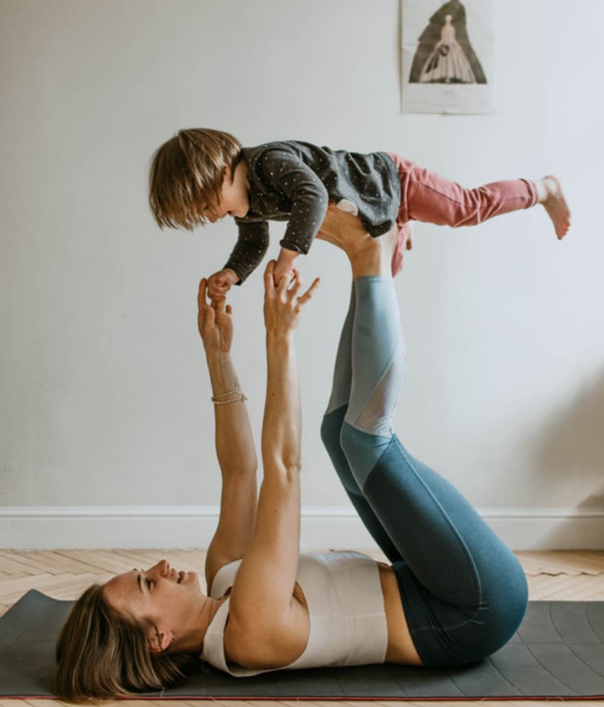 A mom playing airplane with her toddler