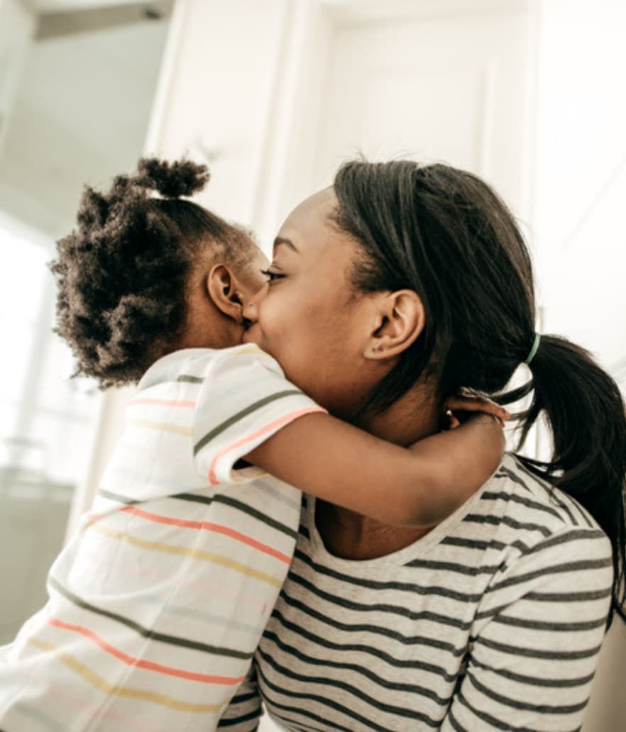 A mom and her toddler sharing a kiss