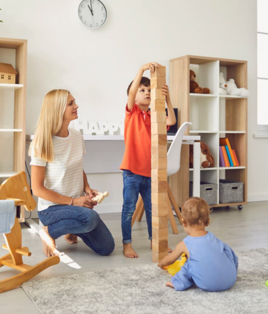 A mom measuring her growing kids against a growth chart