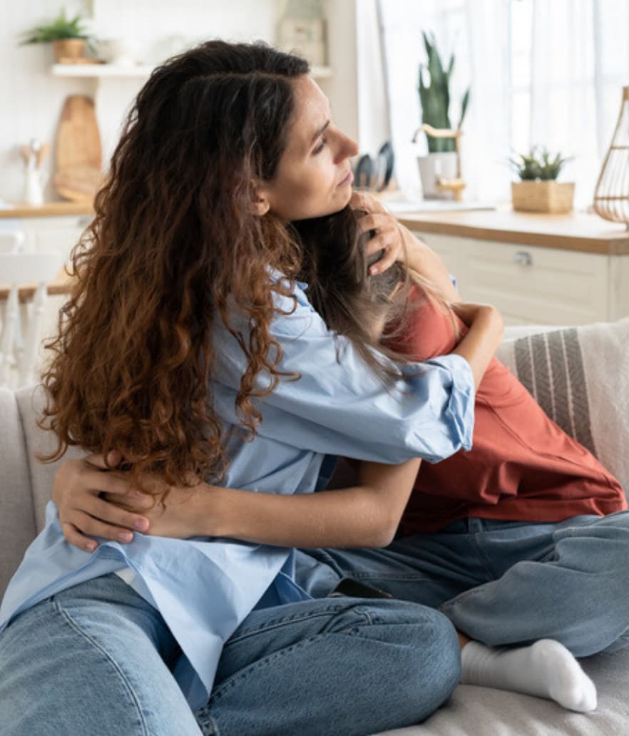A mom holding her tween close