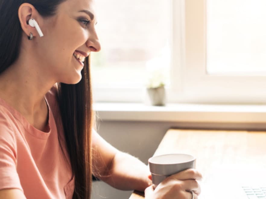 A mom with headphones and a coffee during her virtual therapy session