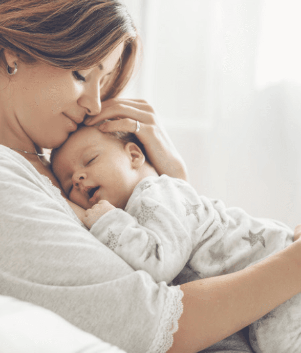 A mom holding her newborn close in a tender moment
