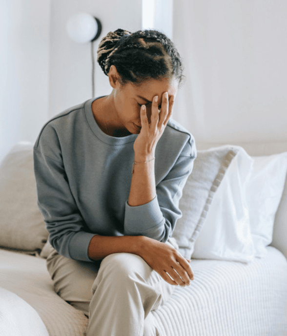 A mom leaning against the kitchen counter looking depleted
