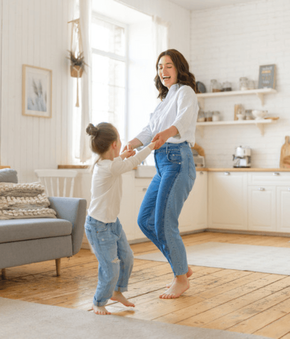 A mom and her young child playing together in a bright living room
