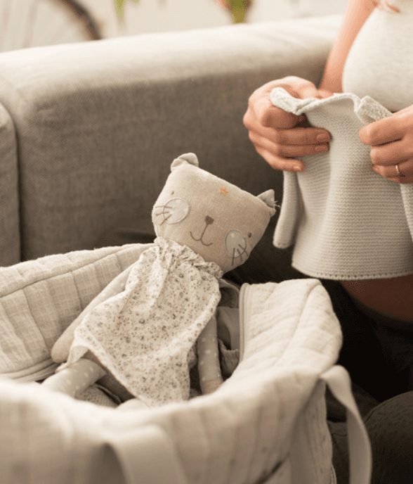 A mom holding her baby close on the couch