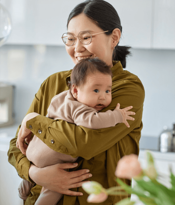 A mom holding her baby close in a warm moment