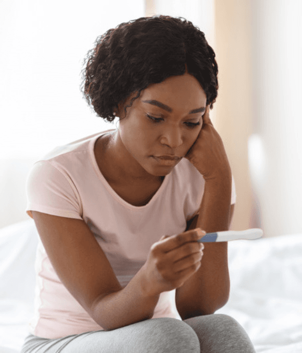 A woman sitting with the weight of trying to conceive