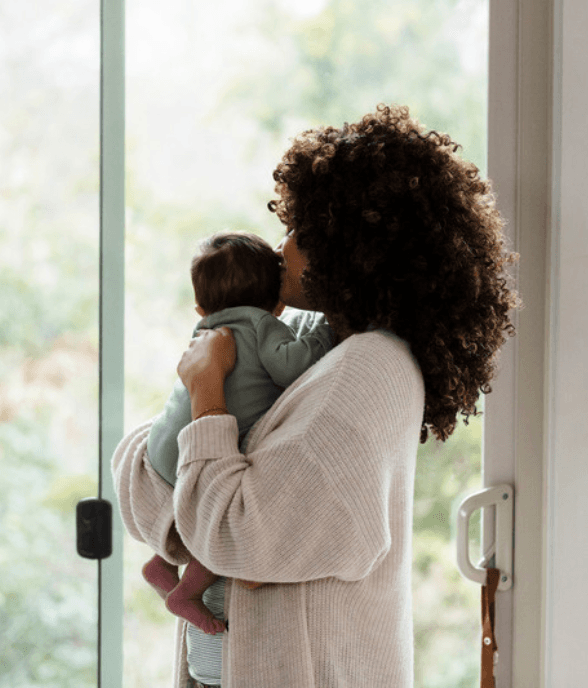 A mom sitting at the kitchen table alone holding a mug of coffee