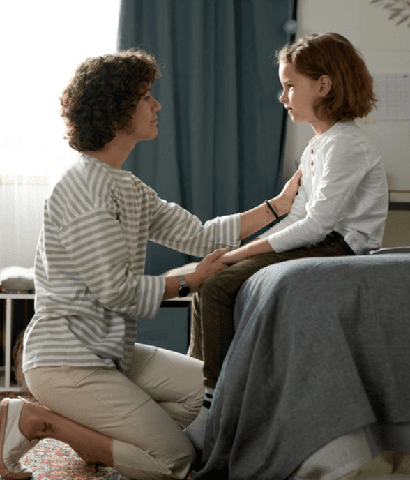 A mom kneeling to reconnect with her child in a calm moment