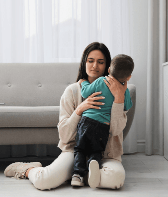 A mom holding her son close in a tender embrace