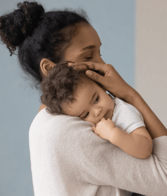 A mom holding her toddler close, needing a moment of calm