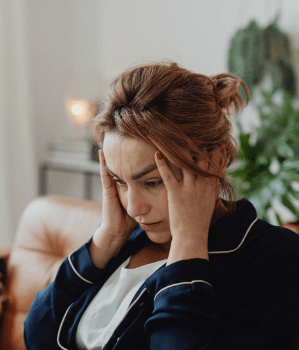 A mom pressing her hands to her face in an overwhelmed moment