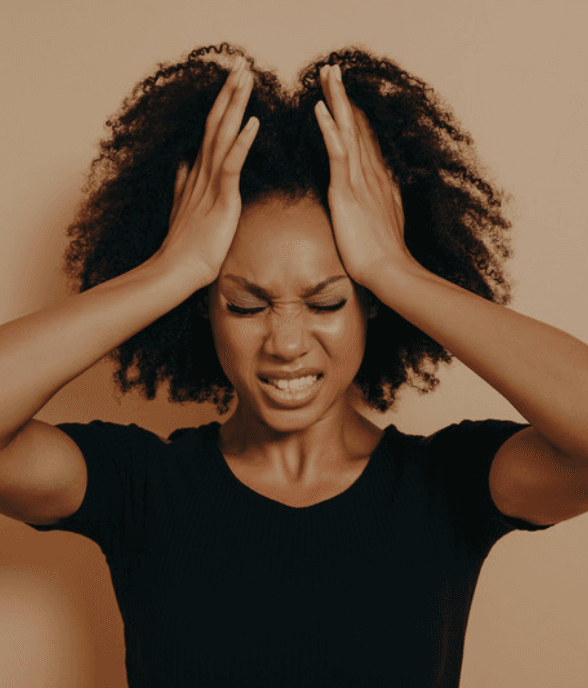 A mom holding her head in a moment of overwhelm at home