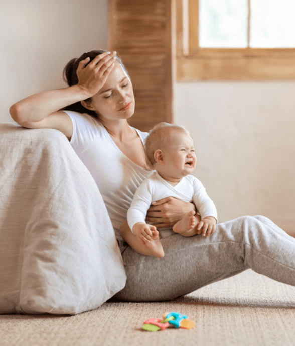 A mom holding her baby through the constant demands of the newborn days