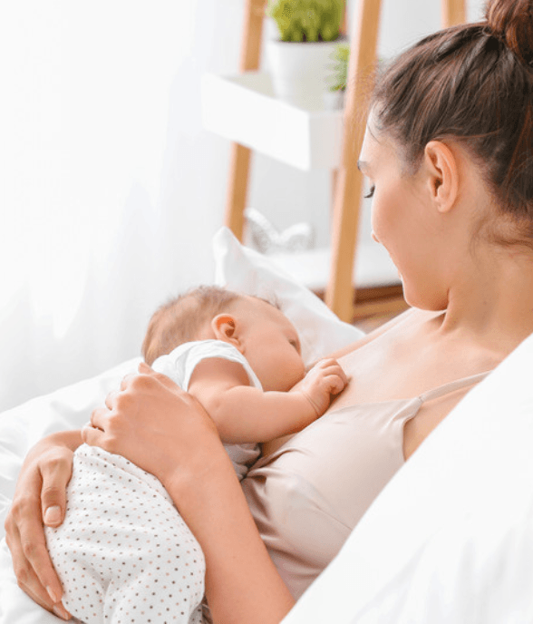 A mom feeding her newborn during a night waking