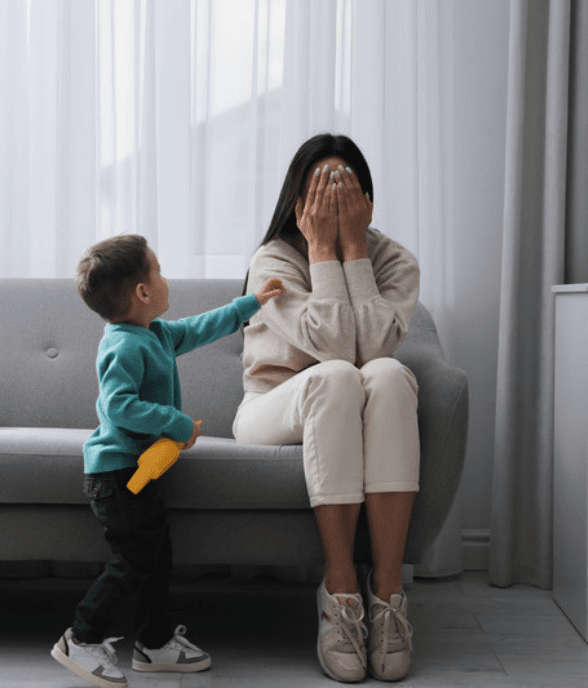 An exhausted mom with her young child at home