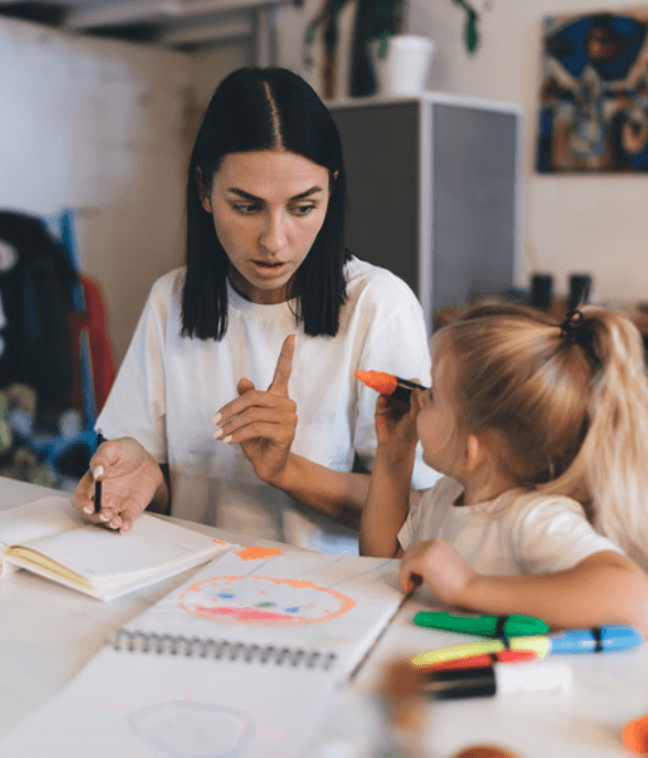 A mom and a young girl at the table together