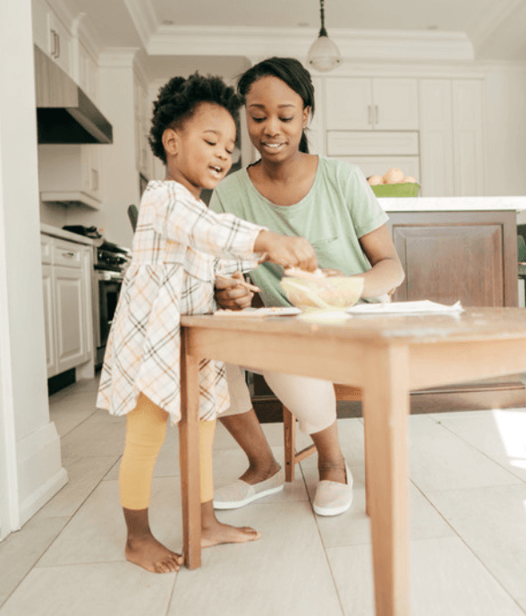 A mom and her stepdaughter baking together in the kitchen