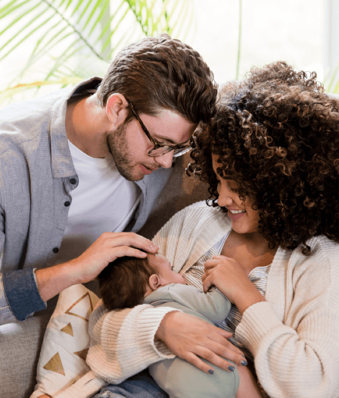 A couple cuddling their newborn together