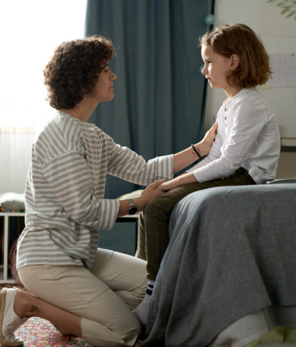 A mom kneeling to reconnect with her child in a calm moment